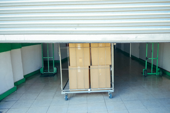 Cart with cardboard box on it inside of storage facility