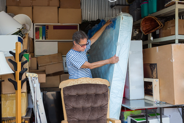 Man storing furniture in a storage container
