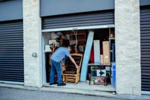 Mann packt Sachen in eine Lagerbox