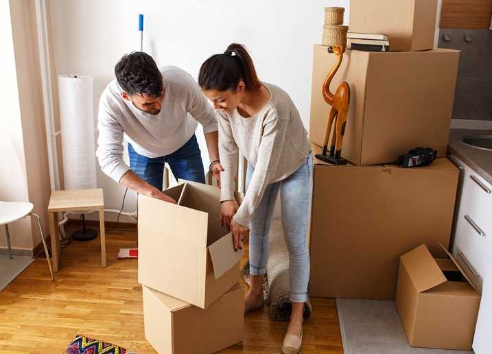 A couple packing cardboard boxes