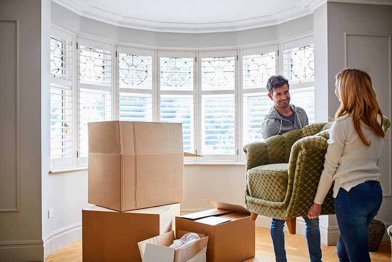 A man and a woman transporting a chair