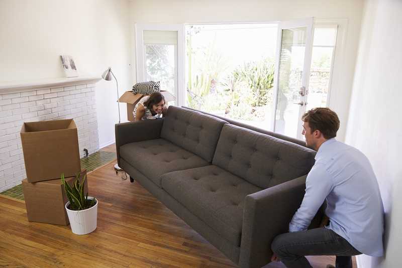 A man and a woman are transporting furniture